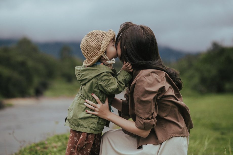 Maman embrassant son enfant avant un voyage accompagné en train avec ClubKids