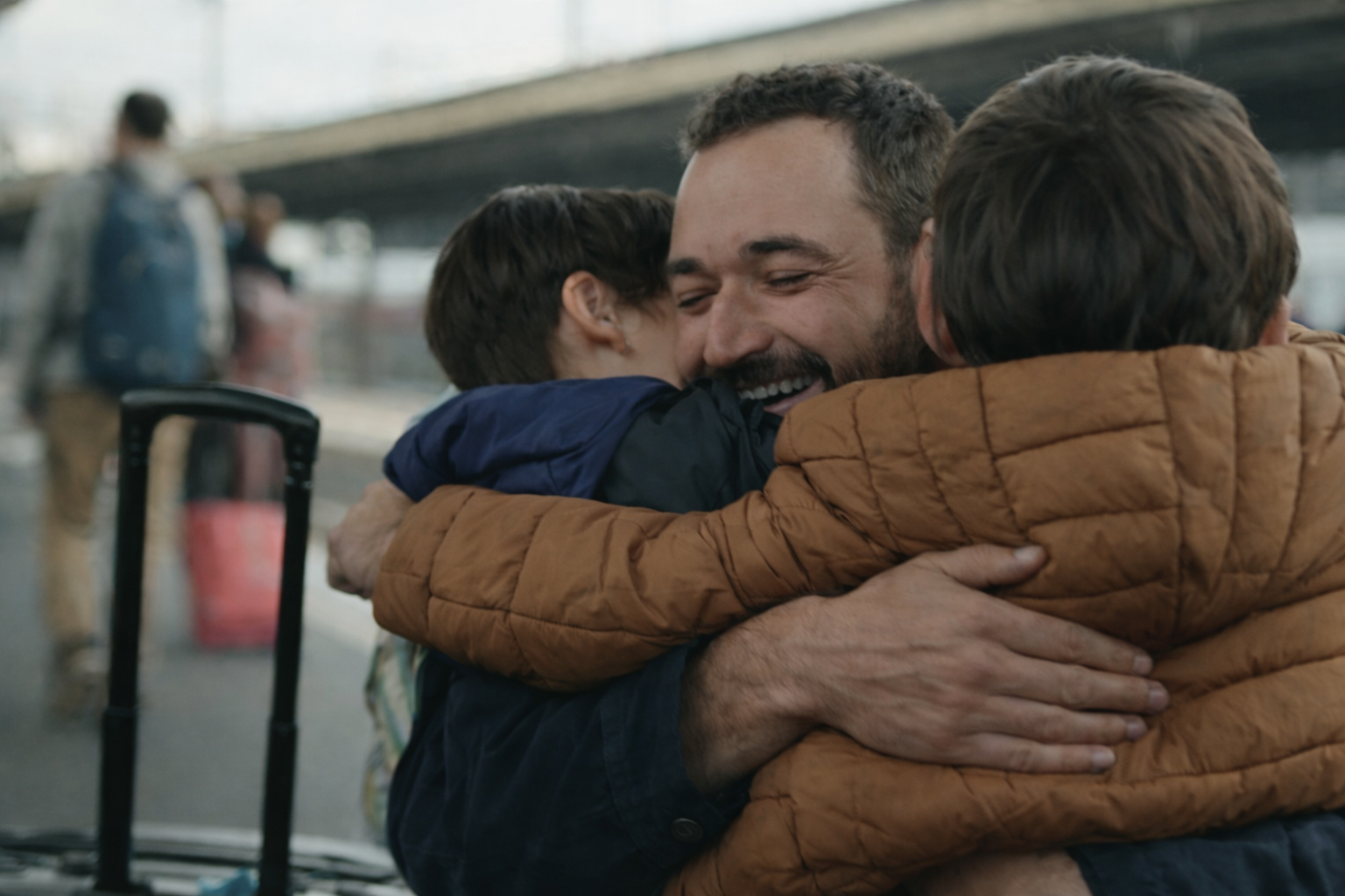 Un père retrouvant ses enfants à l'arrivée